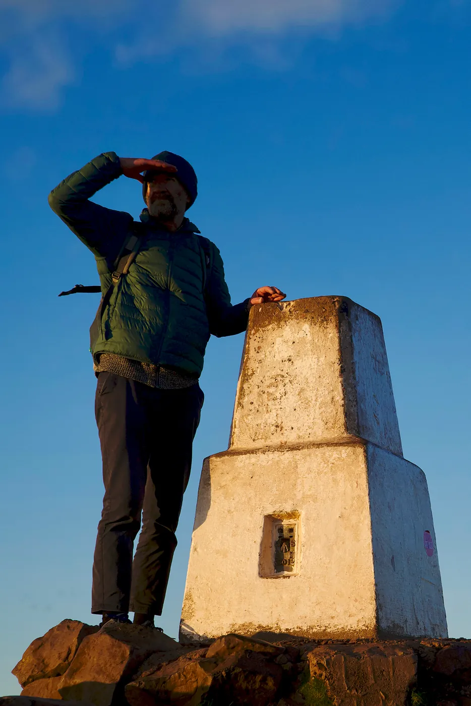 A man observing the landscape from the monument at the zenith of Arthur's Seat.