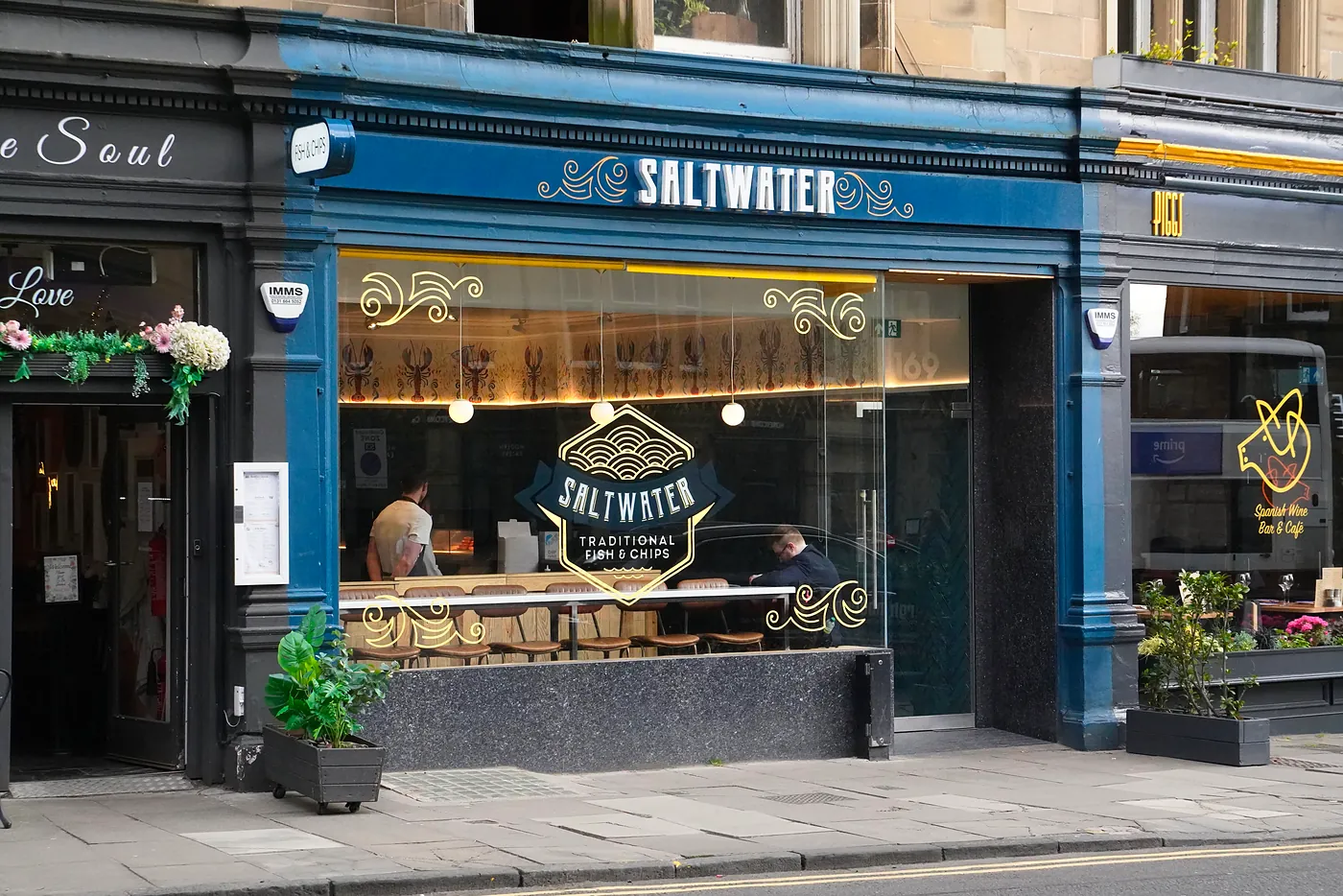 A man waiting for his order in a fish & chip shop on Morningside Road.