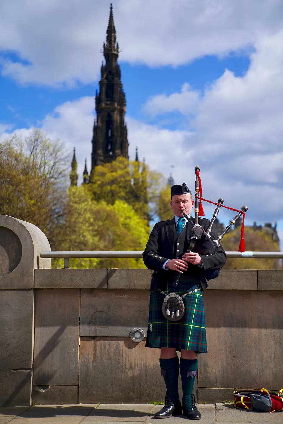 A piper playing in front of the Scott Monument.