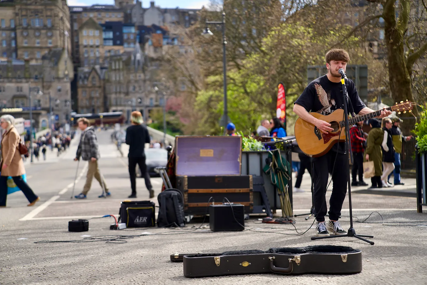 A street musician with the Old Town behind him.