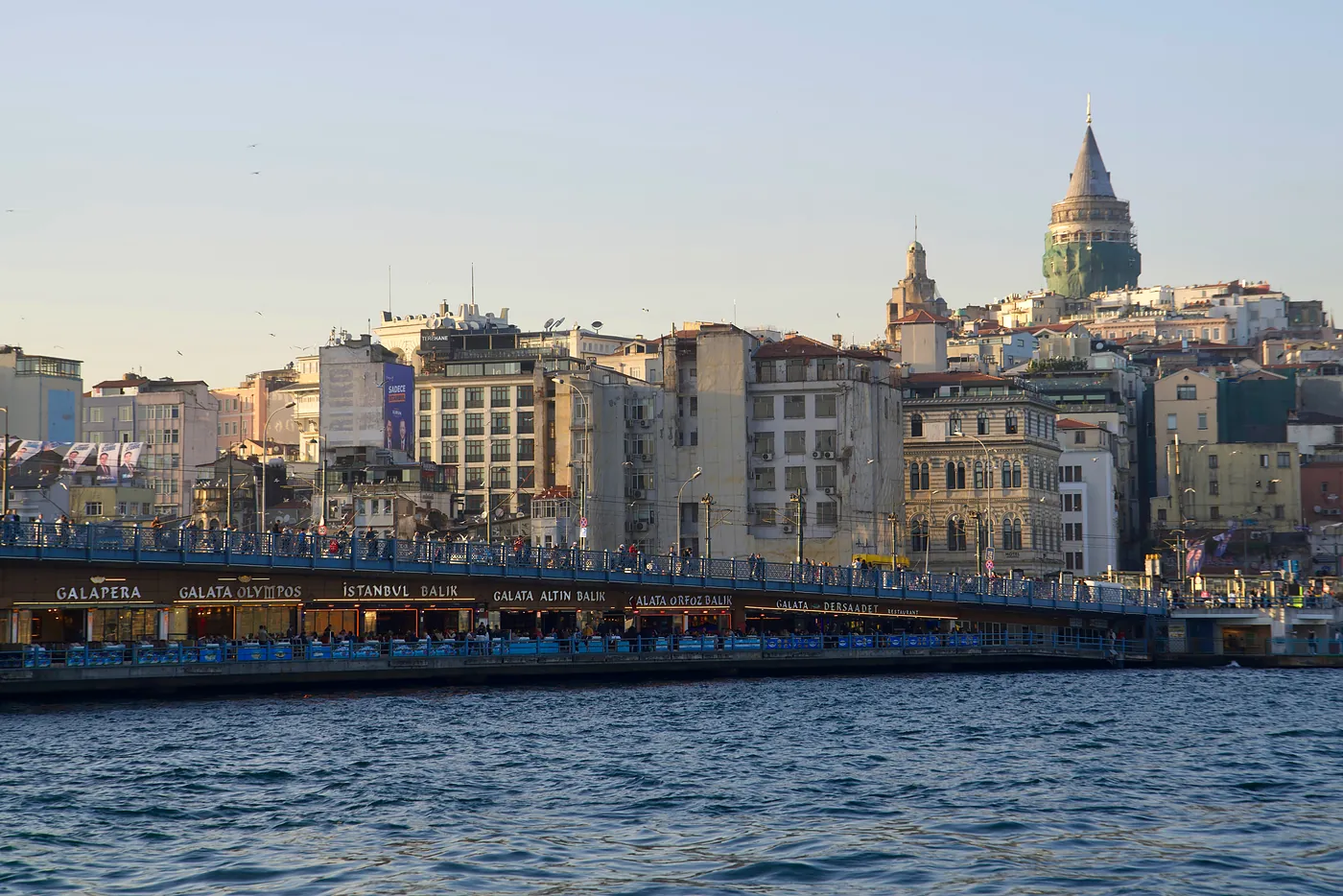 The Galata tower and the northern end of the Galata bridge at sunset. This bridge juts across the Golden Horn and connects Eminönü to Galata.