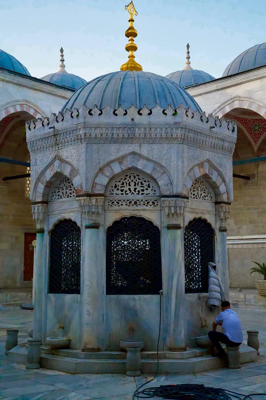 A Turk performing his ceremonial washing in the courtyard before evening prayers.